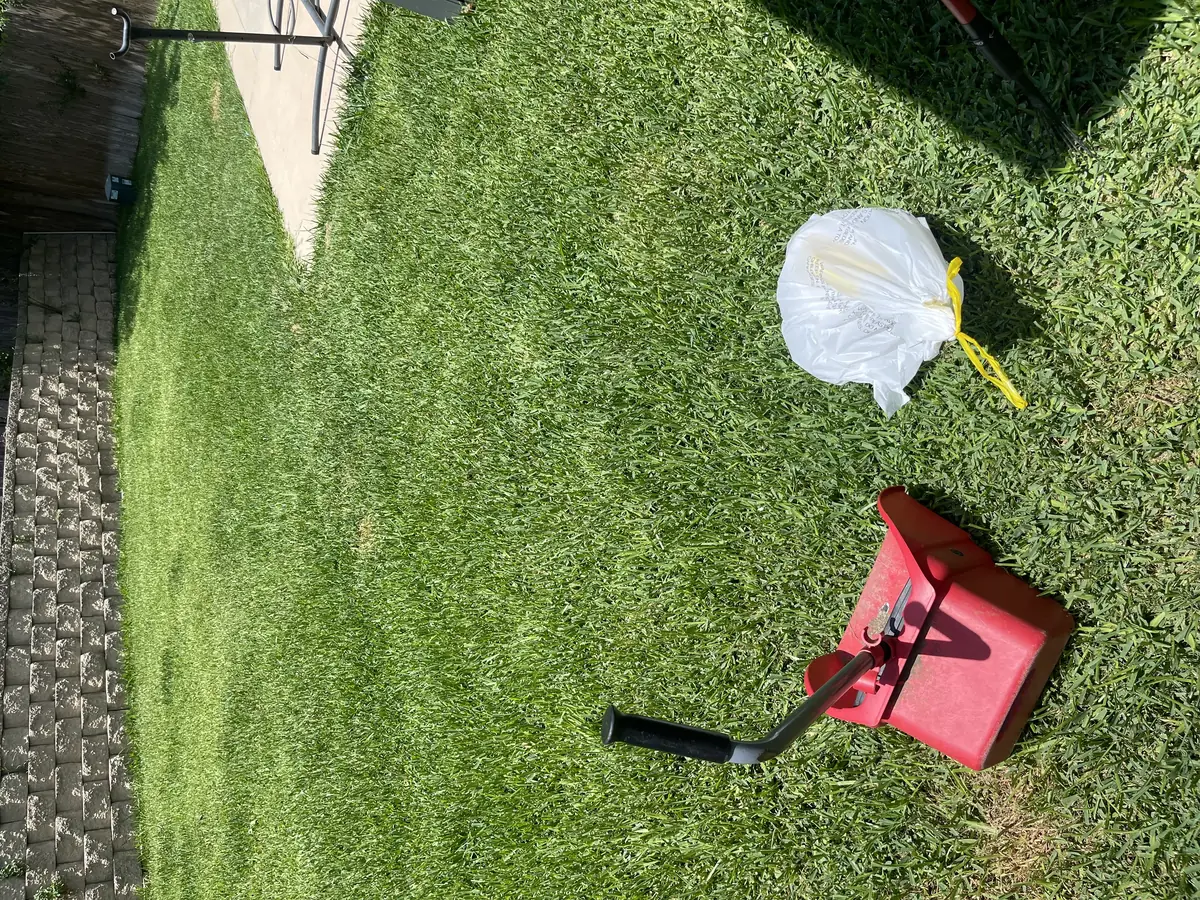 A1 Scoop Warriors pet waste removal completed on a pristine manicured yard with paver pathway and iron gate